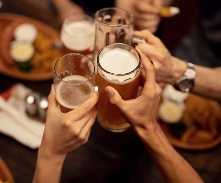 Close up of friends toasting with beer and having fun in a pub.